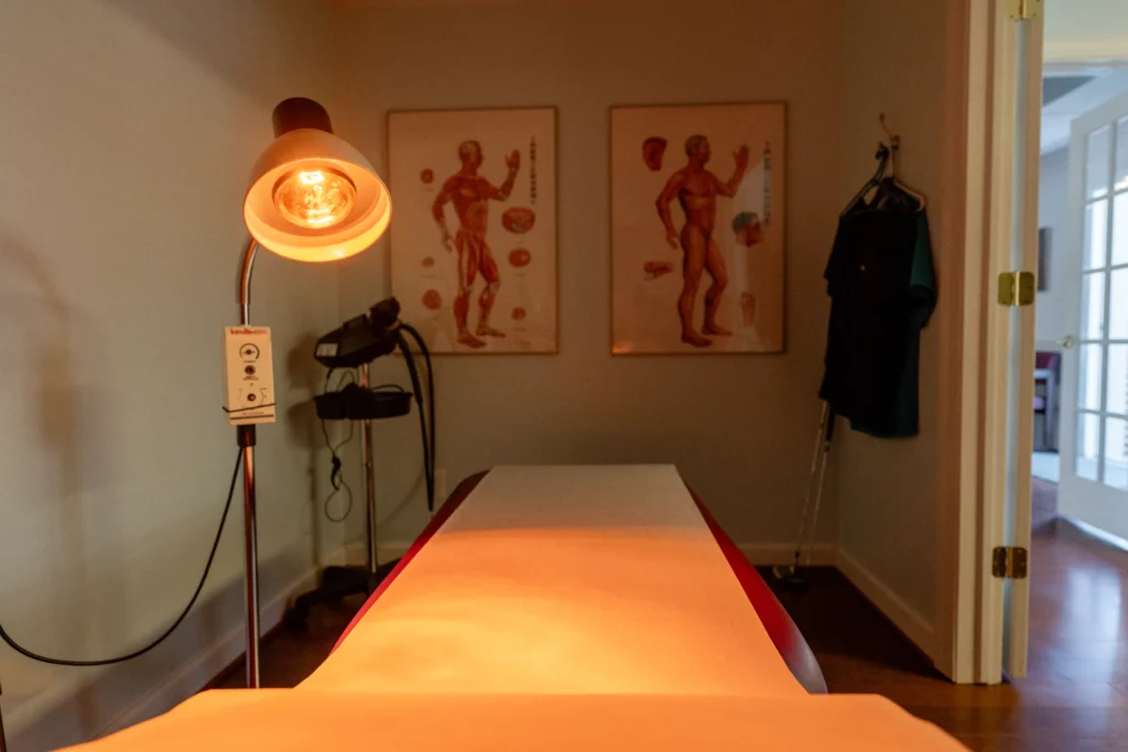 Acupuncture table with body diagrams on wall